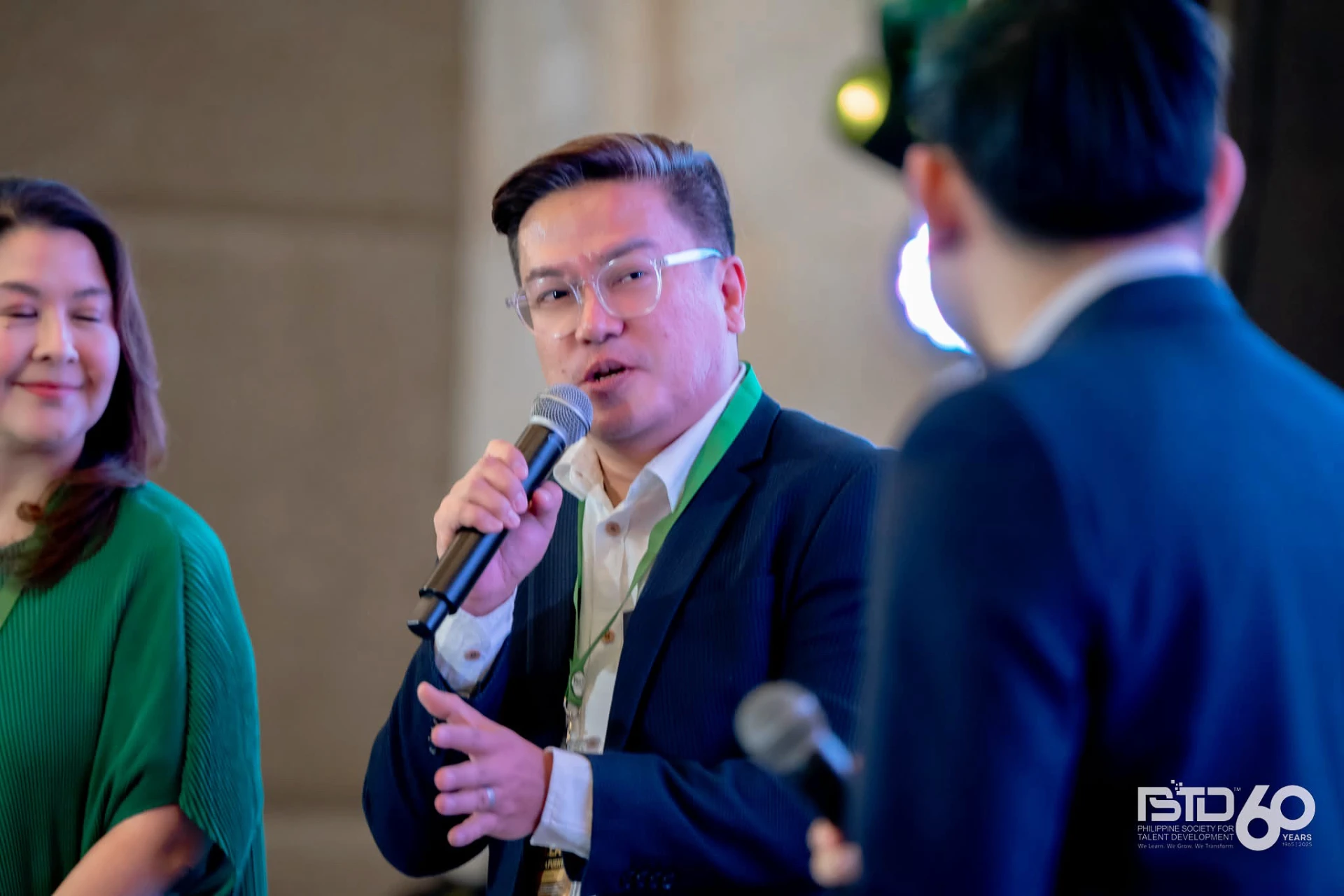 Coach AJ speaking into a microphone at a PSTD event